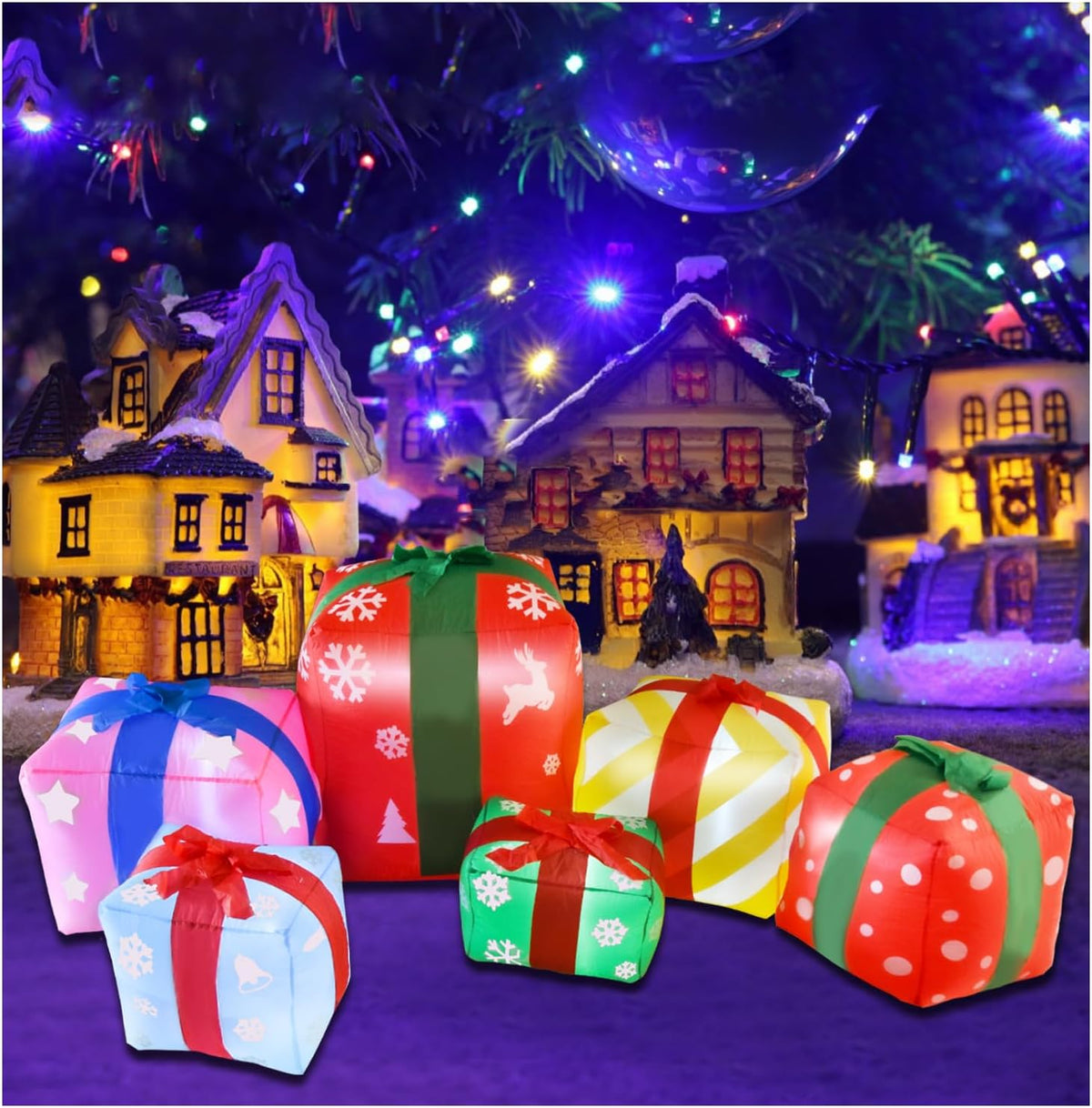 Cluster of colorful inflatable gift boxes glowing in front of a snowy village scene