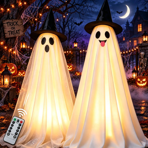 Two glowing white hanging ghosts in black witch hats in a spooky yard at night