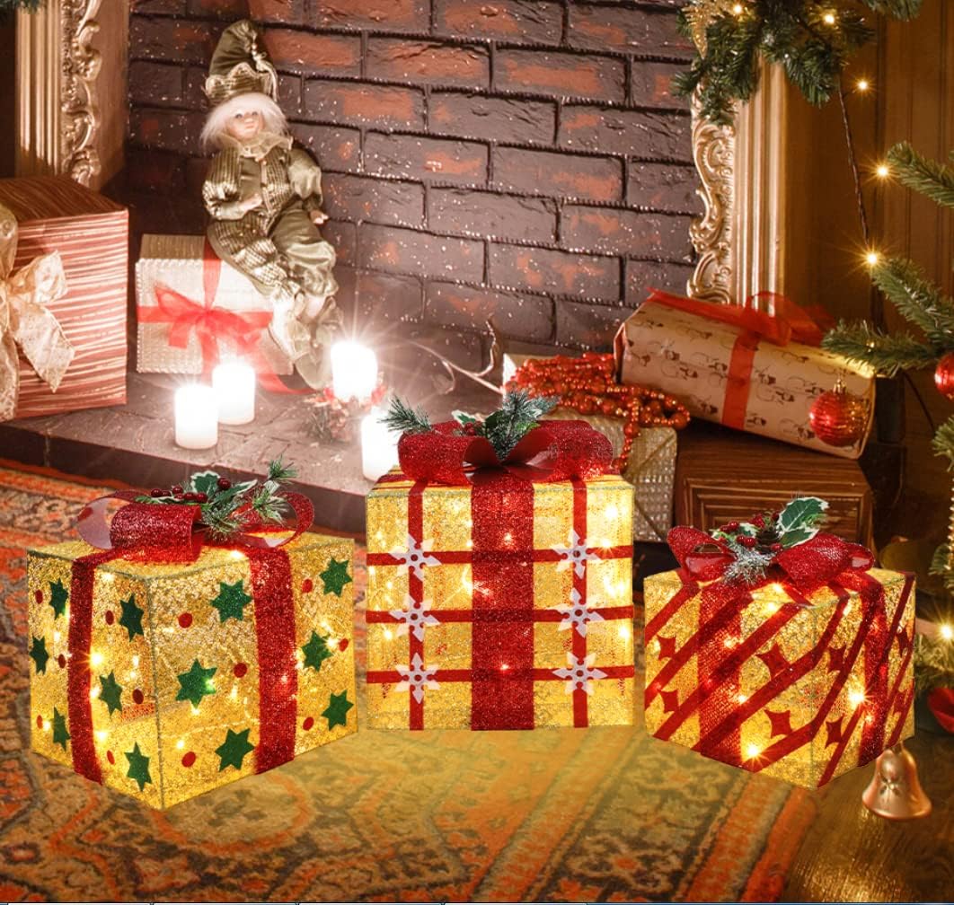 Three lighted gift boxes in graduated sizes with red bows beside a fireplace