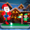 Inflatable Santa putting a golf ball on a green while an elf holds the flag