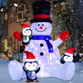 Inflatable snowman in a black top hat with three penguins in Santa hats glowing blue and pink