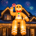 Inflatable gingerbread man with a red bow tie sitting on the edge of a lit-up house roof under fireworks