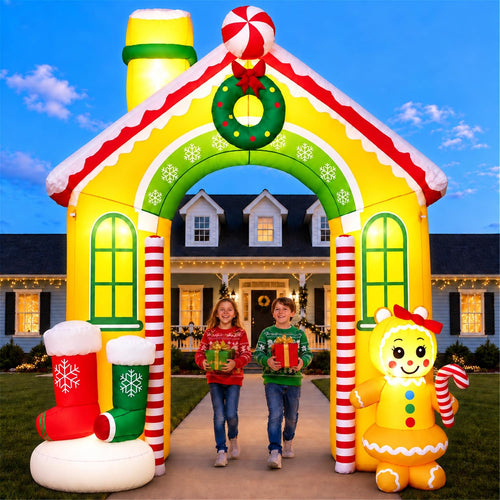 Inflatable gingerbread house archway with a wreath and candy trim, a family walking through