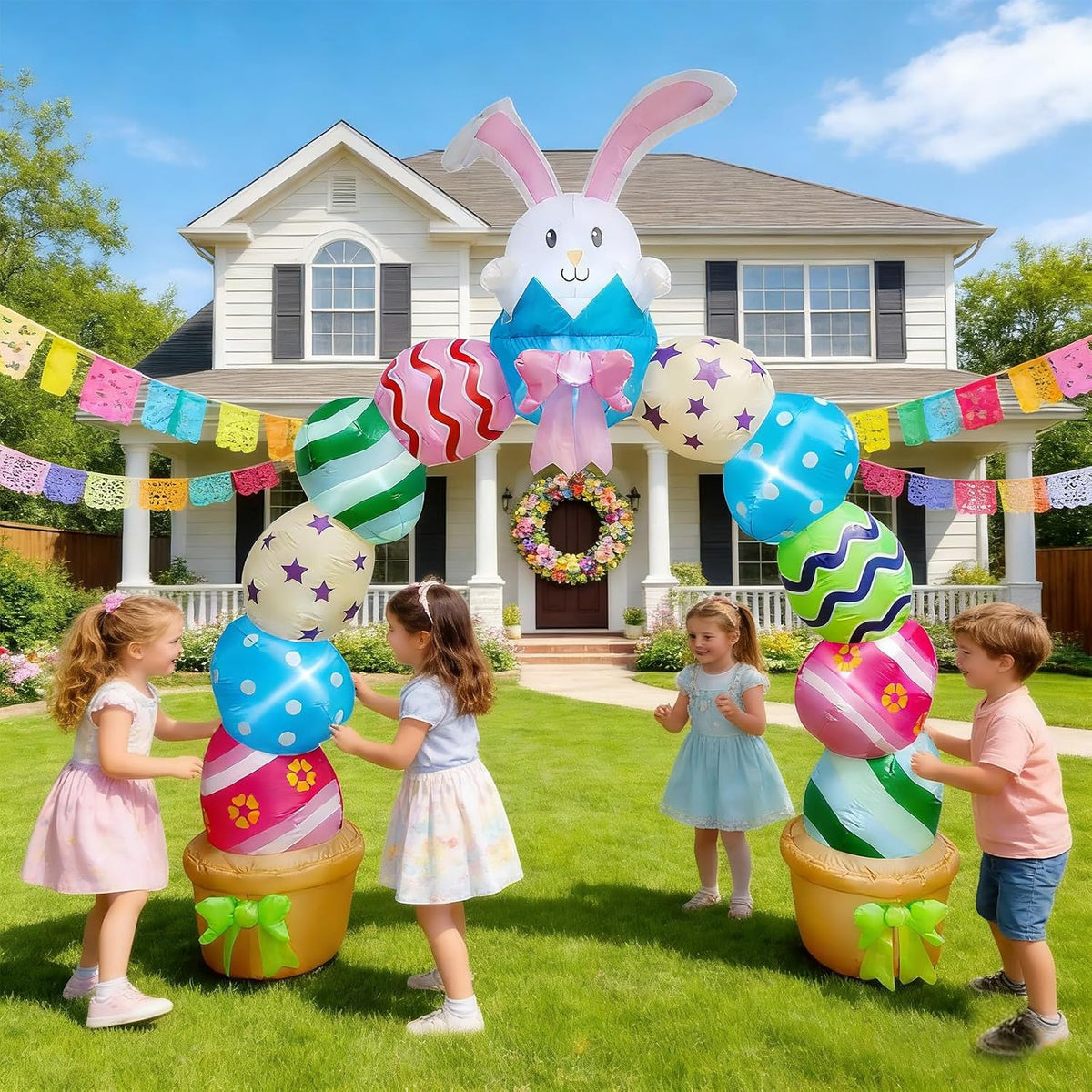 Inflatable pastel Easter archway with a white bunny on top and stacked colorful eggs, children playing underneath