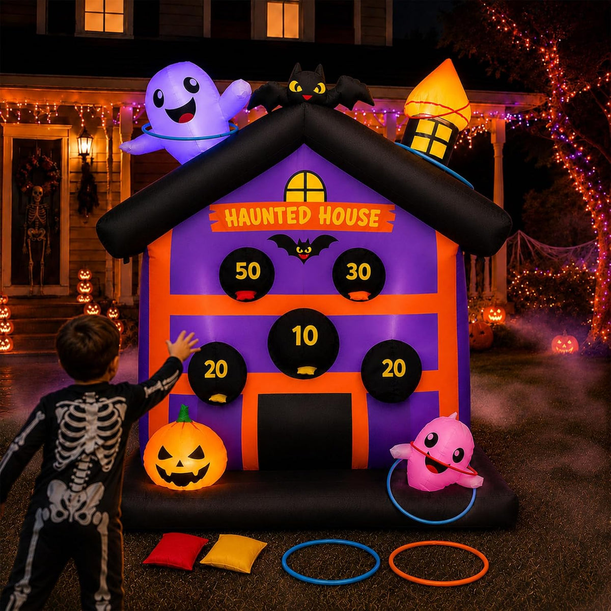 Inflatable purple haunted house toss game with numbered score holes, ghost on the roof and rings on the ground