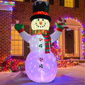 Inflatable snowman in a black top hat and plaid scarf glowing purple in front of a lit house