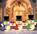 Three pop-up lighted snowmen in top hats and scarves standing in front of a garlanded doorway