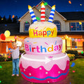Inflatable three-tier Happy Birthday cake with candles glowing in a front yard