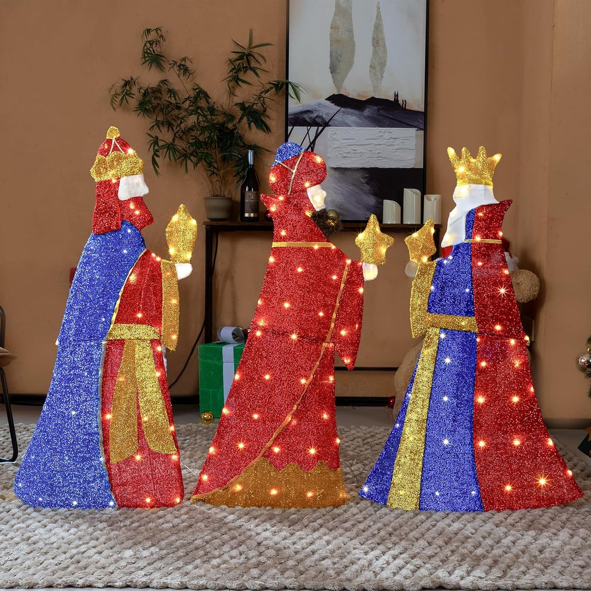 Three pre-lit 2D wise men figures in blue, red and gold robes carrying gifts