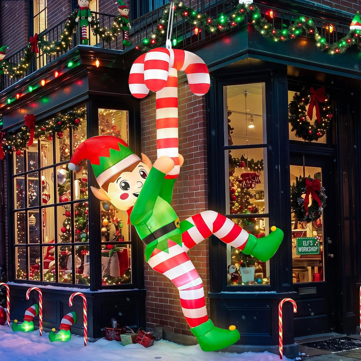 Inflatable elf in a green outfit and striped stockings climbing a red and white candy cane beside a lit house